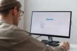 Unemployed man looking for work on the internet sitting at the computer at home