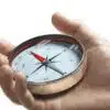 Hand holding a compass over white background. Strategic orientation or direction concept.